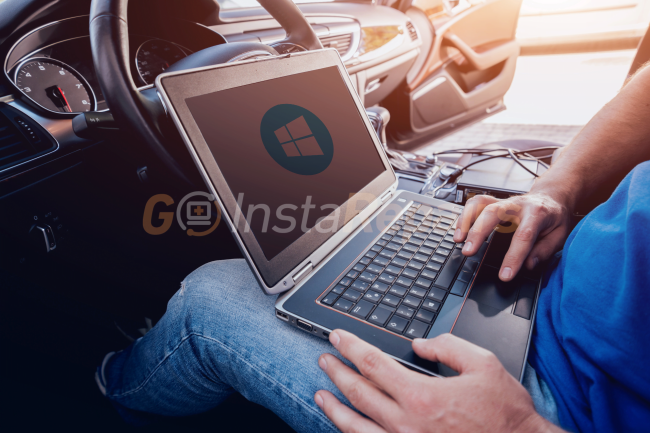 Person working on laptop sitting in a car